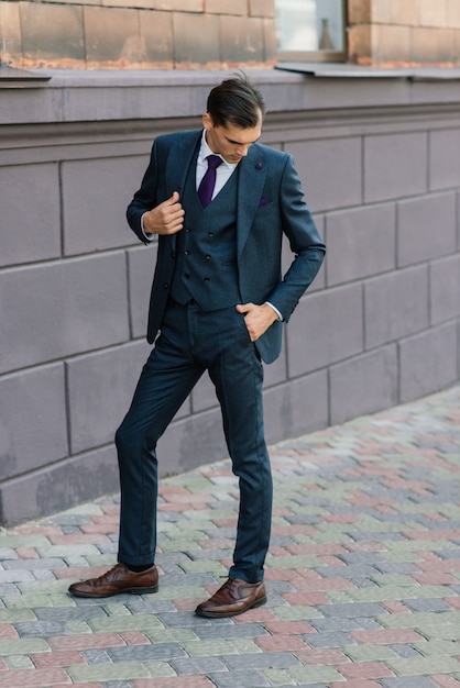 Portrait d'un jeune homme d'affaires séduisant en milieu urbain portant un costume et une cravate.