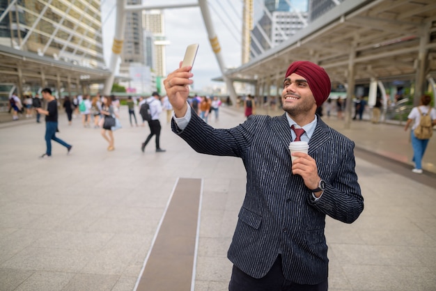 Portrait de jeune homme d'affaires sikh indien beau portant turban tout en explorant la ville de Bangkok, Thaïlande
