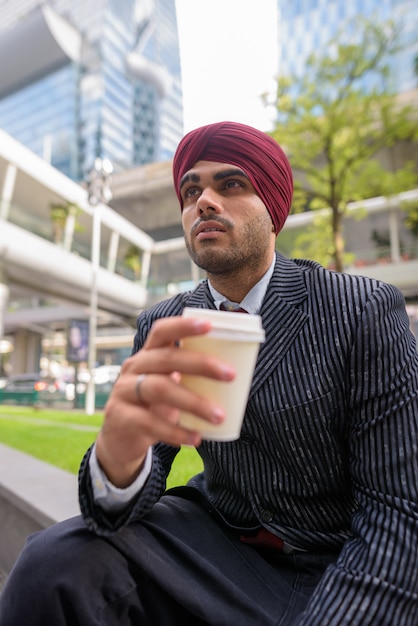 Portrait de jeune homme d'affaires sikh indien beau portant turban tout en explorant la ville de Bangkok, Thaïlande