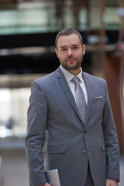 portrait de jeune homme d'affaires avec tablette au bureau moderne