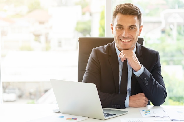 Portrait de jeune homme d&#39;affaires travaillant dans le bureau avec le sourire. Manager ou travail intelligent