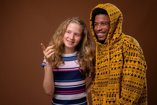 Portrait de jeune homme africain et adolescente caucasienne souriant