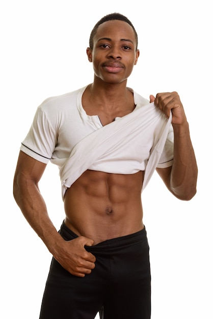 Portrait de jeune homme africain beau montrant abs