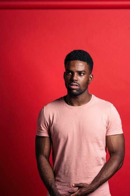 Photo portrait d'un jeune homme africain sur un fond rouge vif