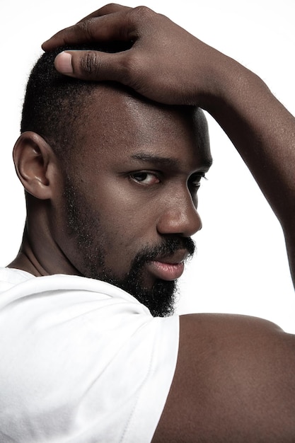 Portrait d'un jeune homme africain sérieux au studio. Modèle masculin de haute couture posant et isolé sur fond blanc