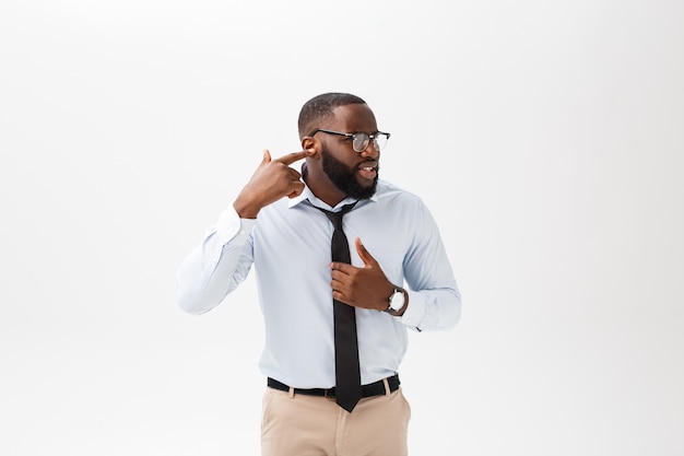 Portrait de jeune homme afro-américain en colère ou agacé en polo blanc en regardant la caméra