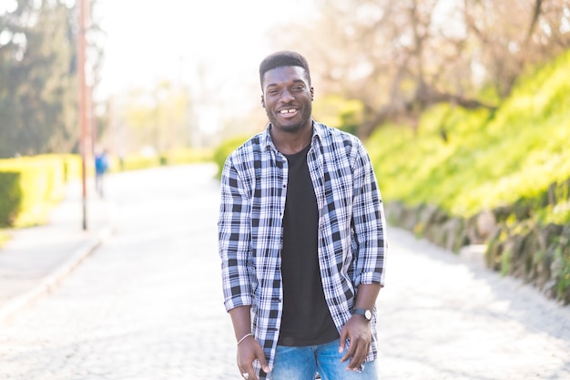 Photo portrait de jeune homme afro-américain noir debout et souriant à la caméra