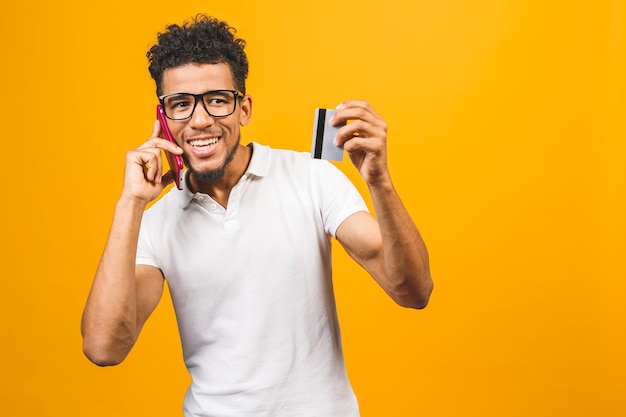 Photo portrait d'un jeune homme afro-américain satisfaits vêtus de vêtements décontractés montrant une carte de crédit en plastique