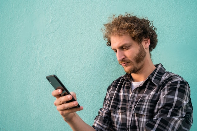 Portrait de jeune homme à l'aide de son téléphone portable