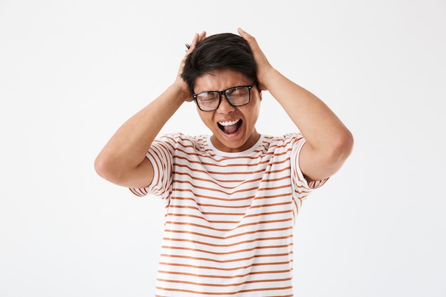 Portrait d'un jeune homme asiatique agacé à lunettes de soleil