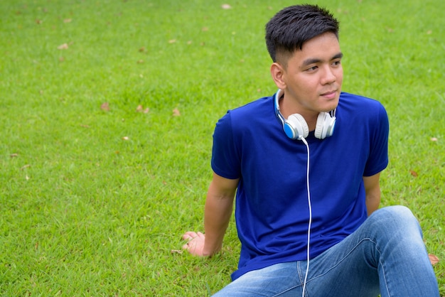 Portrait de jeune homme asiatique beau se détendre dans le parc à Bangkok, Thaïlande