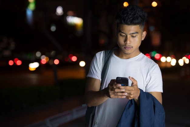 Portrait de jeune homme asiatique dans la rue de la ville pendant la nuit à l'extérieur