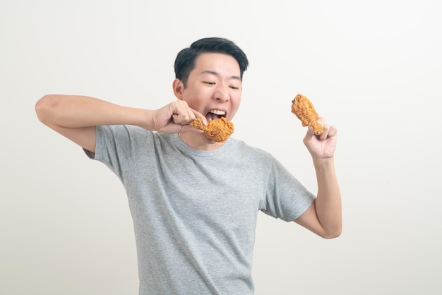 Portrait jeune homme asiatique avec du poulet frit à portée de main