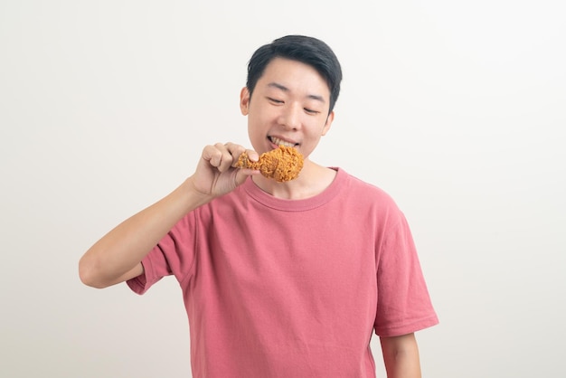Portrait jeune homme asiatique avec du poulet frit à portée de main