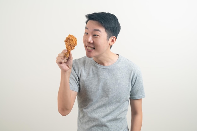 Portrait jeune homme asiatique avec du poulet frit à portée de main