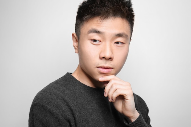 Portrait de jeune homme asiatique sur fond clair