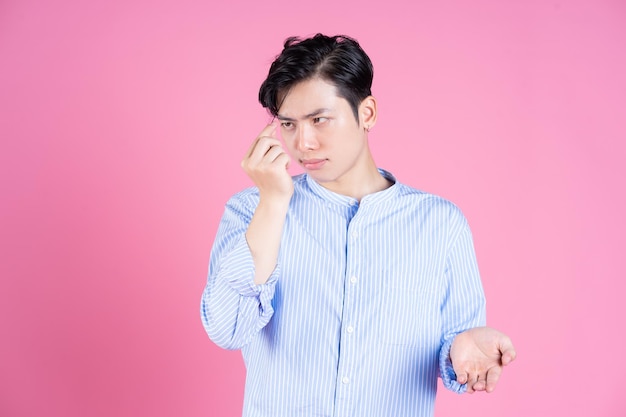 Portrait de jeune homme asiatique sur fond rose