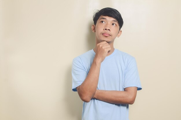 Portrait de jeune homme asiatique pensant sur fond isolé