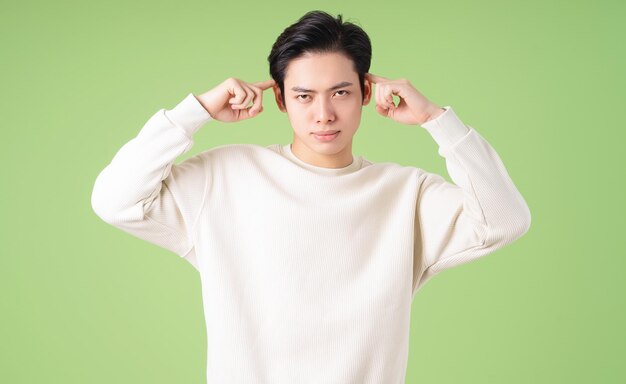 Portrait de jeune homme asiatique posant sur fond vert
