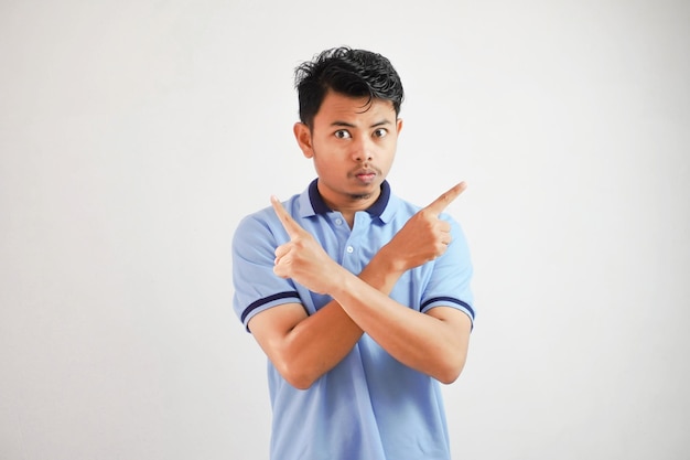 Portrait d'un jeune homme asiatique réfléchi, bras croisés, doigts pointés vers le haut, portant un t-shirt bleu