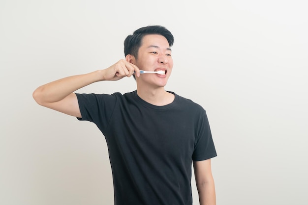 Portrait jeune homme asiatique se brosser les dents