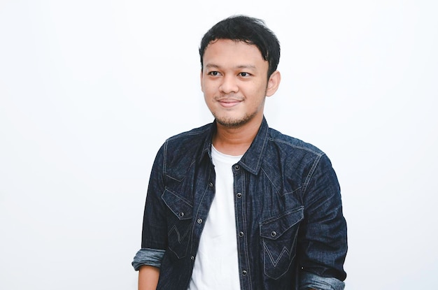 Portrait d'un jeune homme asiatique souriant portant une chemise blanche et un pantalon en jean isolé sur blanc