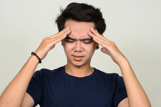 Photo portrait de jeune homme asiatique stressé ayant des maux de tête