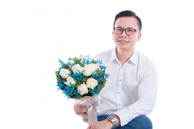 Portrait de jeune homme asiatique tenant des fleurs