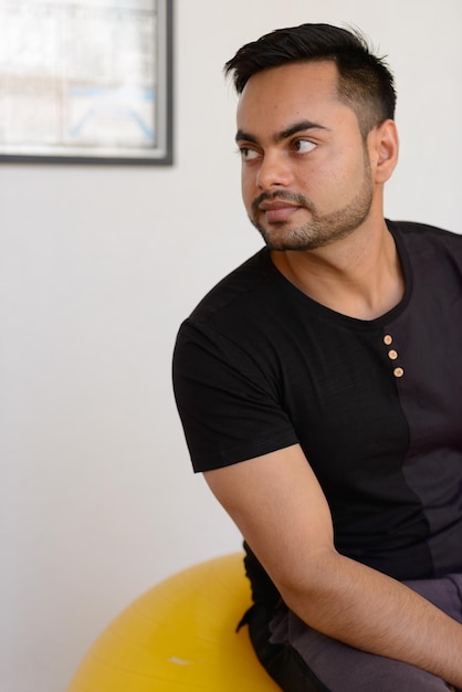 Portrait d'un jeune homme assis contre le mur