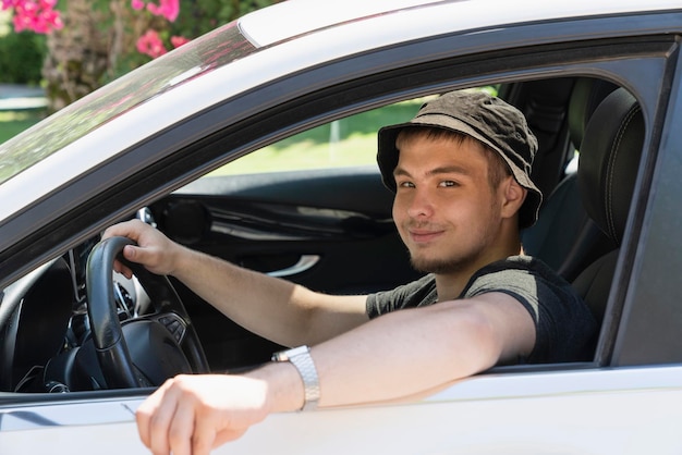 Portrait d'un jeune homme assis dans une voiture