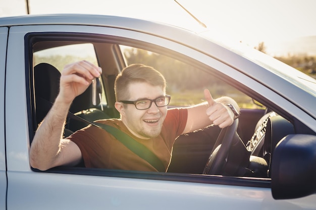 Portrait d'un jeune homme assis dans une voiture