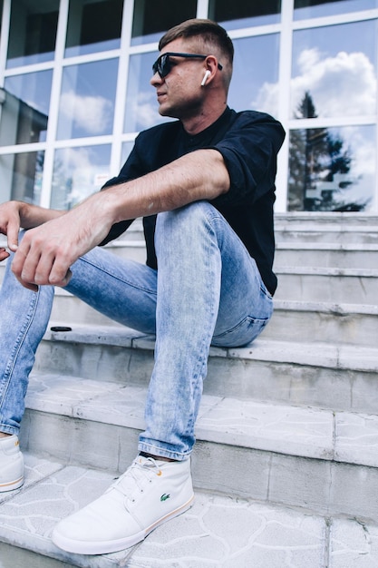 Photo portrait d'un jeune homme assis sur l'escalier