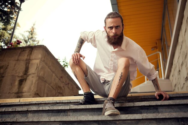 Portrait d'un jeune homme assis sur un escalier