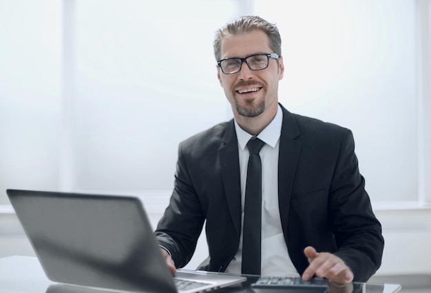 Portrait de jeune homme assis à son bureau au bureau