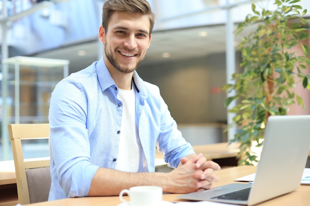 Portrait de jeune homme assis à son bureau au bureau.