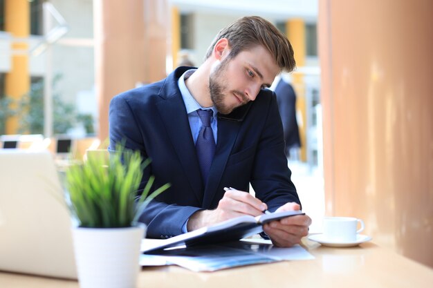 Portrait de jeune homme assis à son bureau au bureau.