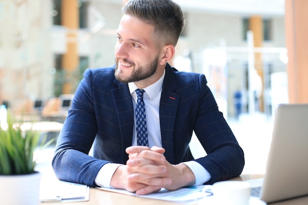 Portrait de jeune homme assis à son bureau au bureau.