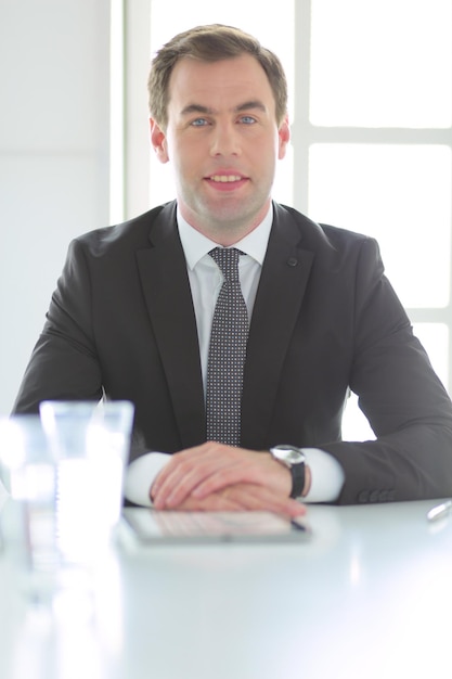 Portrait de jeune homme assis à son bureau dans le bureau