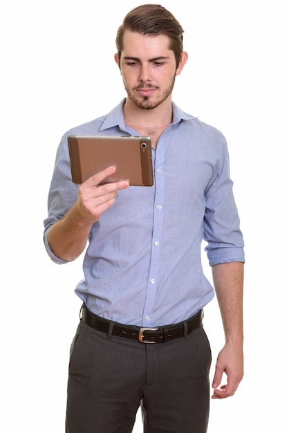 Portrait de jeune homme barbu beau à l'aide de tablette numérique