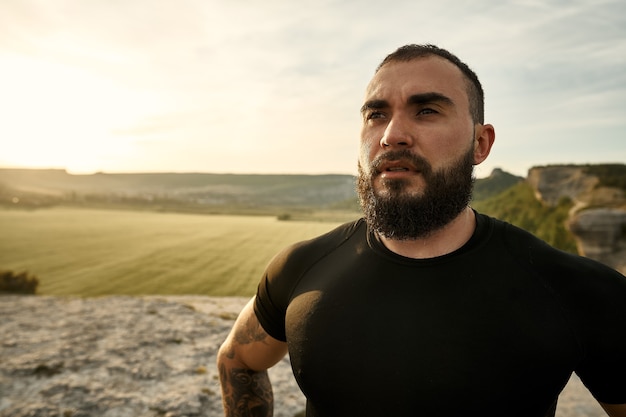 Portrait de jeune homme barbu à l'extérieur dans les montagnes