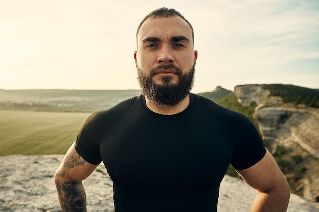 Portrait de jeune homme barbu à l'extérieur dans les montagnes