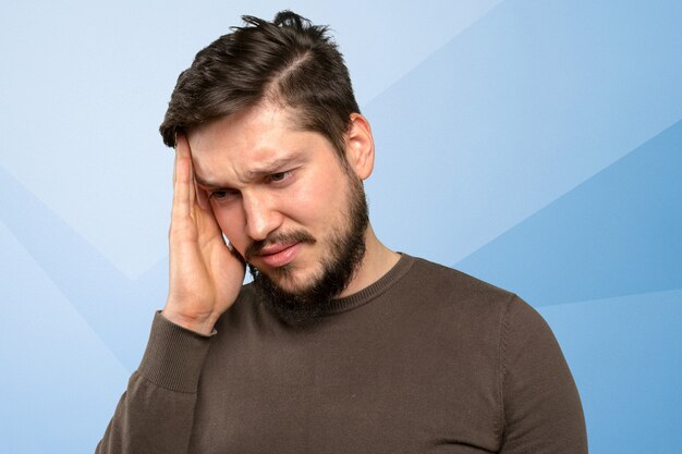 Portrait d'un jeune homme barbu fatigué et irrité