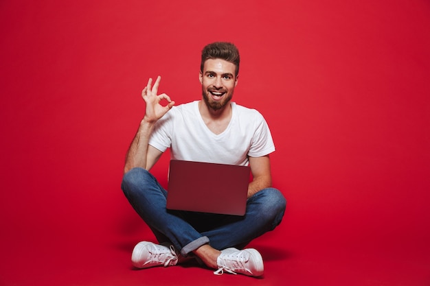 Portrait d'un jeune homme barbu heureux montrant ok