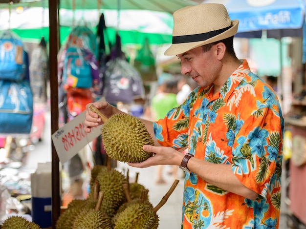 Portrait de jeune homme beau touriste au marché de rue en plein air