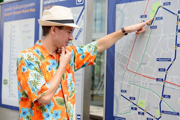 Portrait de jeune homme beau touriste à la station de métro dans la ville