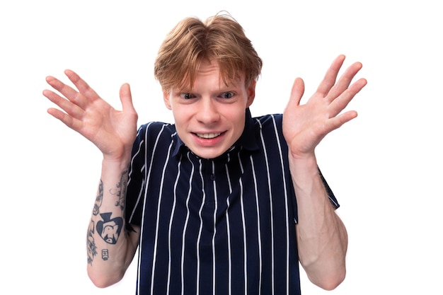 portrait d'un jeune homme blond bien entretenu dans une chemise polo rayée sur un fond blanc