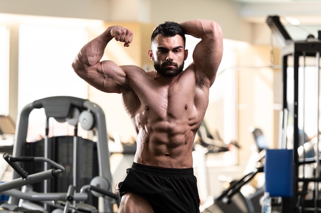 Portrait d'un jeune homme en bonne forme physique montrant son corps bien formé Muscular Athletic Bodybuilder Fitness Model Posing After Exercises