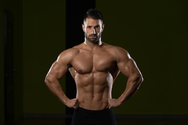 Portrait d'un jeune homme en bonne forme physique montrant son corps bien formé Muscular Athletic Bodybuilder Fitness Model Posing After Exercises