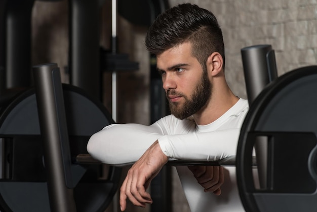 Portrait d'un jeune homme en bonne forme physique se reposant dans un club de santé moderne