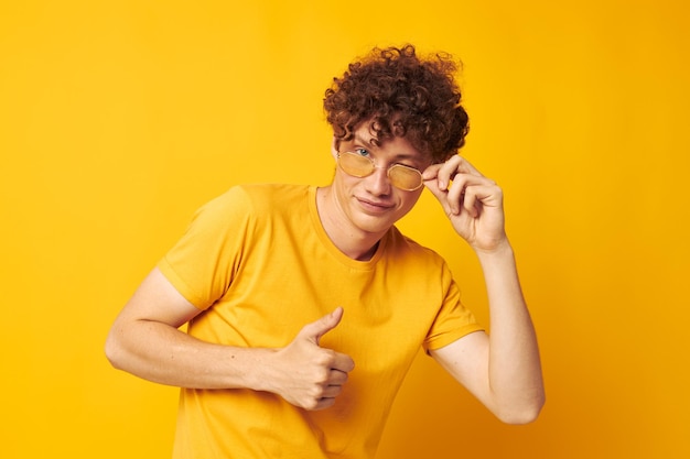 Portrait d'un jeune homme bouclé lunettes de style jeunesse studio vêtements décontractés tir monochrome